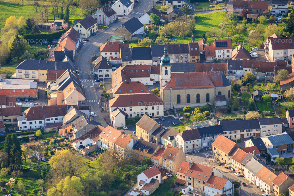 Aerial view: Saint Wendelin Church at Jardin St Wendelin in Diebling in the state Moselle, France. – Photo: IMG_154240.jpg taken on 04/17/2026 by Werner Riehm/FLY-FOTO.com – Resolution of the original: 5543 x 3695 px – Archiprêtré de Sarreguemines - Diocèse de Metz
