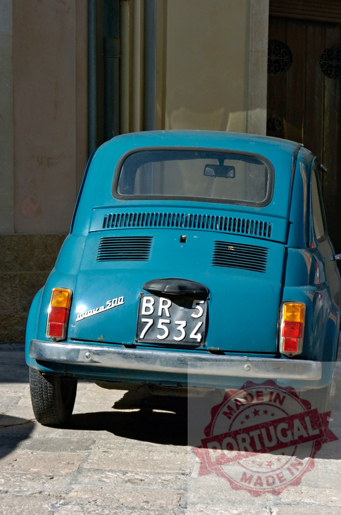 Vintage blue Fiat 500 parked on cobblestone street in Italy | Classic light blue Fiat 500 showing rear view with Italian license plate on historic street - Realized with Pictrs.com