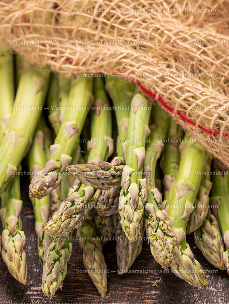 Nahaufnahme von fristen und rohen grünen Spargelstangen auf alten Holzbrett | Nahaufnahme von fristen und rohen grünen Spargelstangen auf alten Holzbrett, abgedeckt mit einen Sack - Realisiert mit Pictrs.com