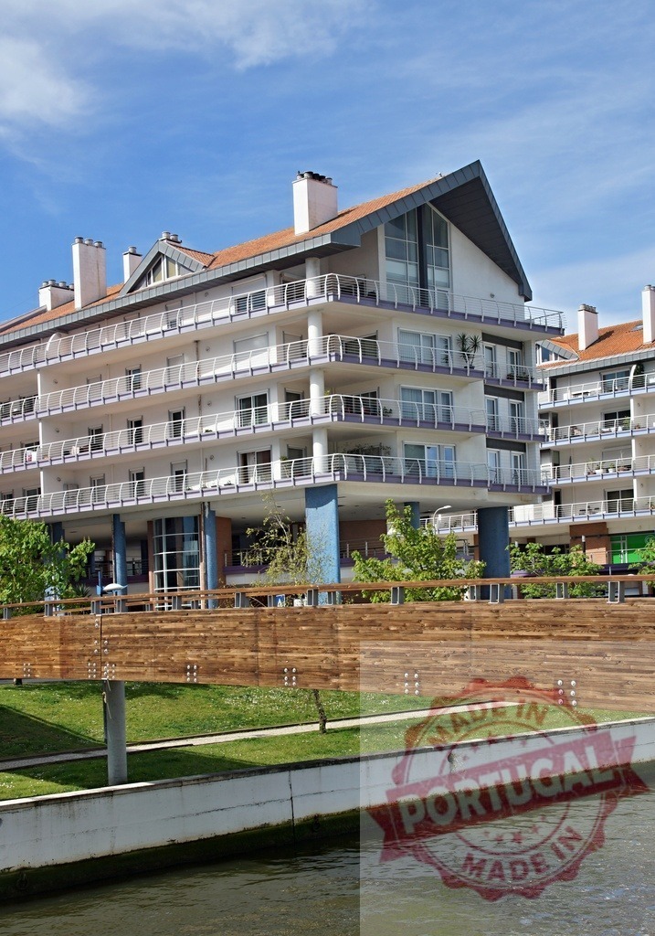 Modern apartment building along a canal with bridge. Aveiro - Portugal | Modern apartment building presenting balconies along a canal and wooden pedestrian bridge - Realisiert mit Pictrs.com