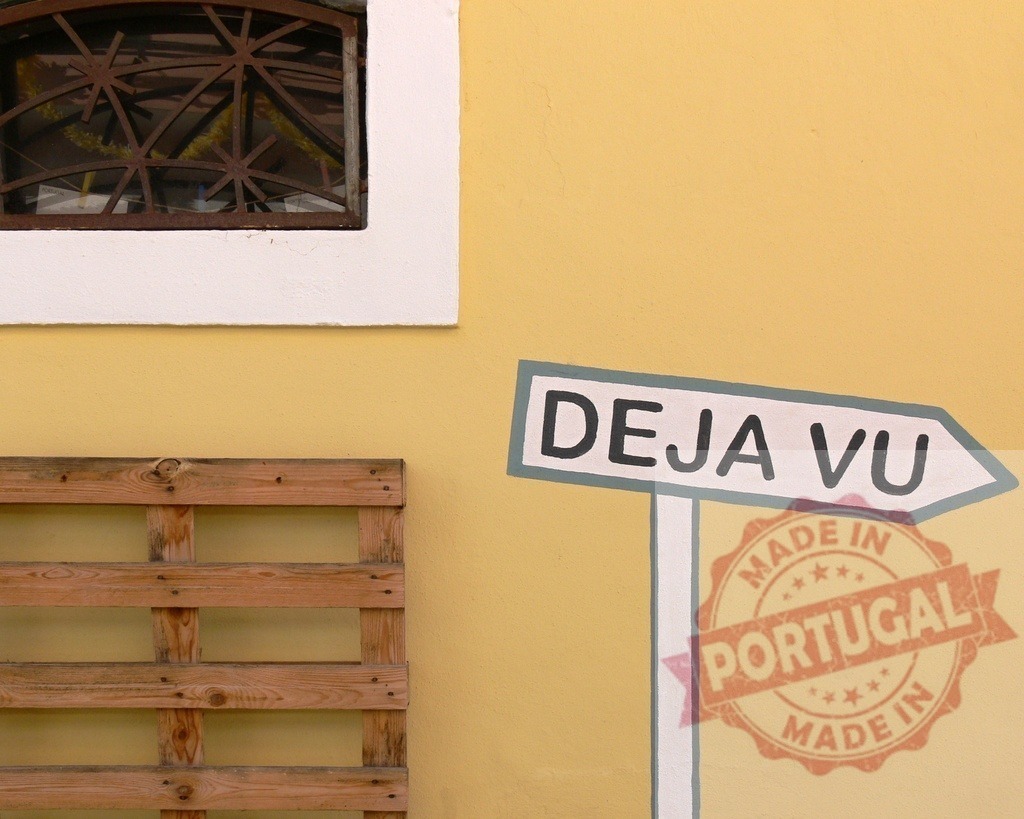 Deja Vu sign pointing left on yellow wall | Deja Vu sign painted on a vibrant yellow wall with a window and a wooden pallet - Realized with Pictrs.com