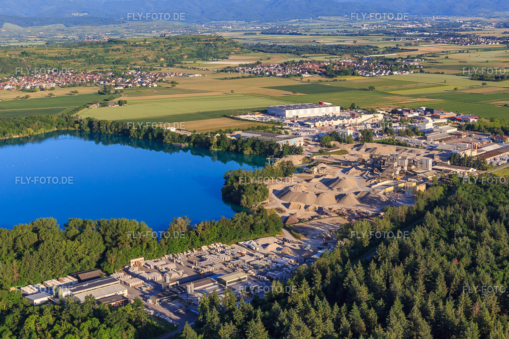 Rimsinger Baggersee / Kiesgrube  Niederrimsingen mit Betonwerk Müller GmbH & Co. KG, P & S-Beton GmbH & Co. KG und H+H Kalksandstein GmbH  http://www.beton-mueller.de/ http://www.beton-ps.de/ http://www.hplush.de/ | Luftbild: Rimsinger Baggersee / Kiesgrube  Niederrimsingen mit Betonwerk Müller GmbH & Co. KG, P & S-Beton GmbH & Co. KG und H+H Kalksandstein GmbH  http://www.beton-mueller.de/ http://www.beton-ps.de/ http://www.hplush.de/ im Ortsteil Oberrimsingen in Breisach im Bundesland Baden-Württemberg in Deutschland. Foto: IMG_147807.jpg vom 30.05.2025 durch Werner Riehm/FLY-FOTO.de - Realisiert mit Pictrs.com