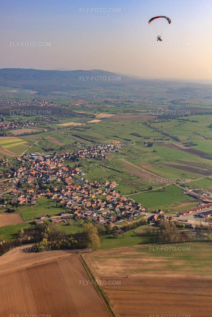 Aerial view: Village view from the southwest with paraglider in Gunstett in the state Bas-Rhin, France. – Photo: IMG_63761.jpg taken on 03/30/2014 by Werner Riehm/FLY-FOTO.com – Resolution of the original: 3168 x 4752 px
