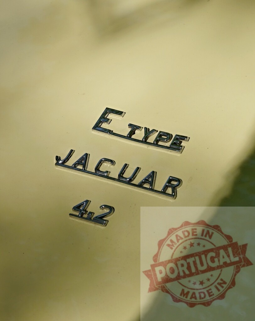 Jaguar E-Type 4.2 Litre classic car badge | Jaguar E-Type 4.2 Litre chrome logo on a vintage yellow automobile - Realized with Pictrs.com