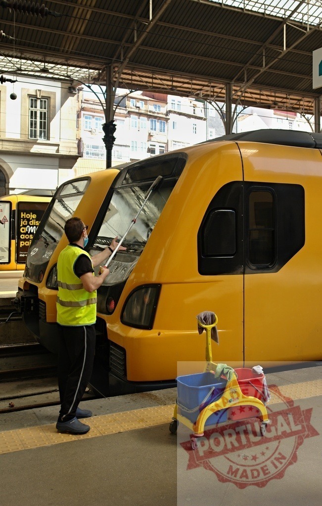 Worker cleaning yellow train windshield at São Bento station | Worker cleaning a yellow train with washing equipment at São Bento train station platform - Realisiert mit Pictrs.com