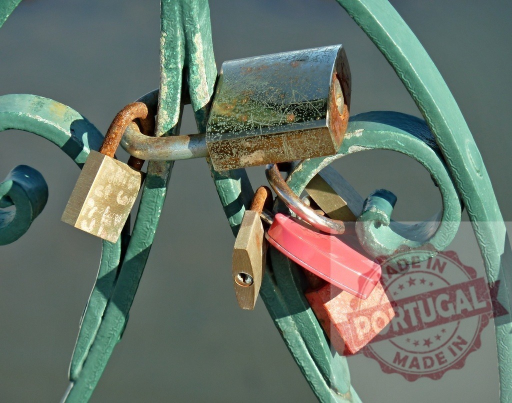 Love locks hanging on old bridge railing | Padlocks symbolize lasting love and commitment locked onto a green metal fence - Realized with Pictrs.com