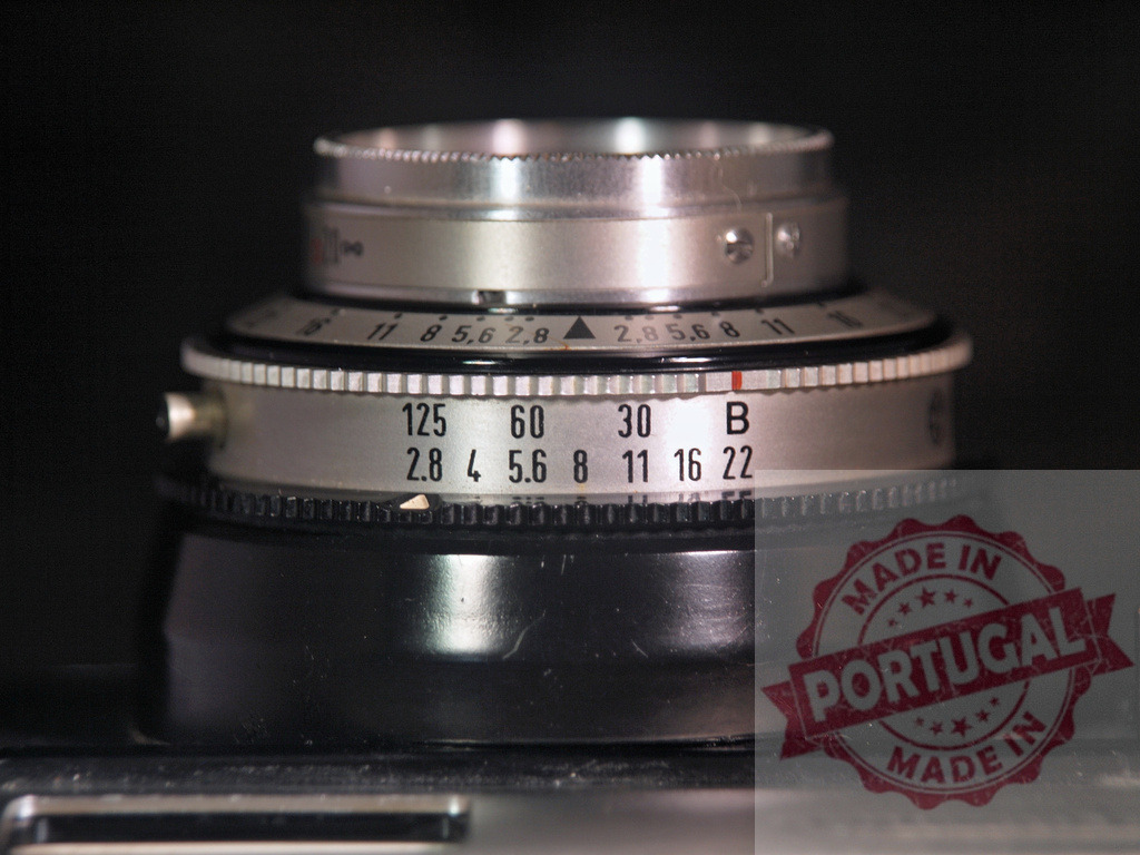 Vintage camera lens showing aperture and shutter speed controls | Close-up of a vintage camera lens dial with f-stop and shutter speed settings on a dark background - Realized with Pictrs.com