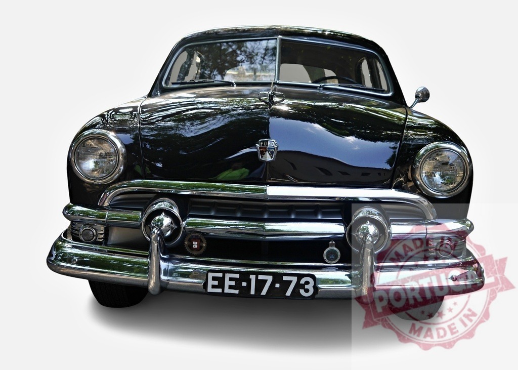 Shiny black Ford Custom Deluxe Sedan reflecting trees | Classic Ford Custom Deluxe Sedan with a shiny black paint job reflecting surrounding trees - Realisiert mit Pictrs.com