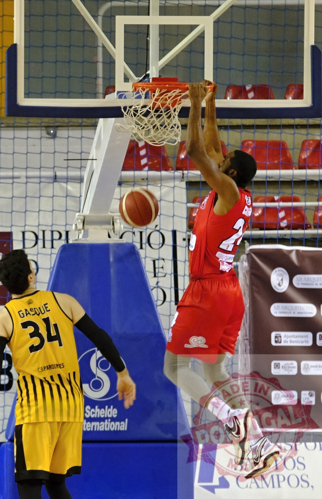 Basketball player performing powerful slam dunk action | Athlete in red jersey hanging on rim after scoring a dynamic slam dunk - Realized with Pictrs.com