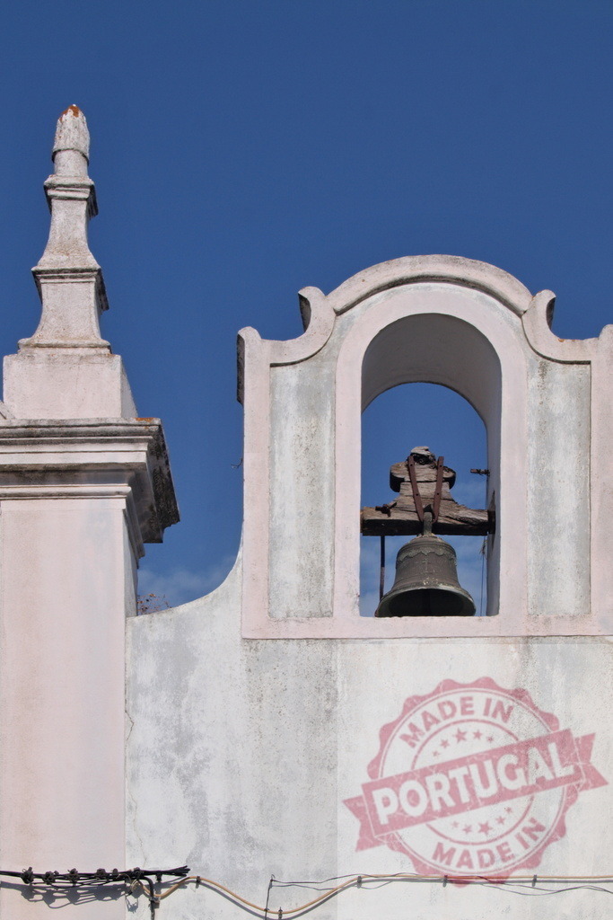 Church bell tower bell against blue sky | Church bell hanging in its bell tower showing architectural details against clear blue sky - Realized with Pictrs.com