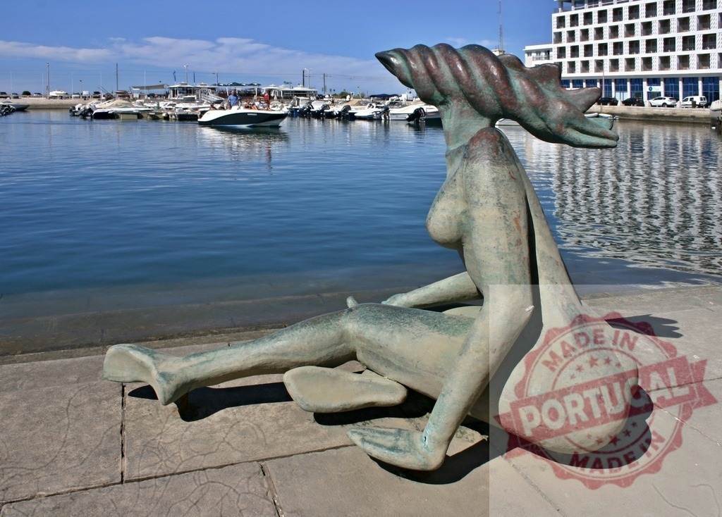 Bronze woman sculpture sitting by Portimao marina | Bronze sculpture of a woman reflecting on the water at a sunny marina - Realisiert mit Pictrs.com
