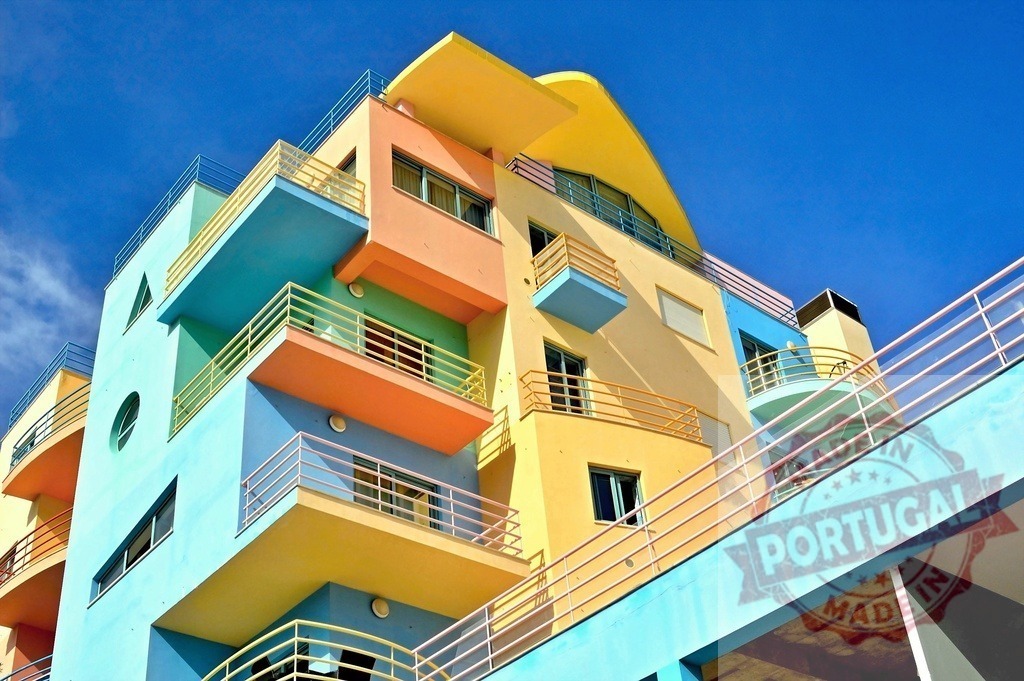 Colorful modern architecture building with geometric balconies | Colorful, modern building showing geometric shapes and diverse balconies under a bright blue sky - Realisiert mit Pictrs.com