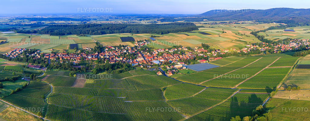 Luftbild: Dorf-Panorama aus Nordosten in Steinseltz im Bundesland Bas-Rhin in Frankreich. – Foto: IMG_100663-Pano-2.jpg vom 02.06.2017 durch Werner Riehm/FLY-FOTO.de – Auflösung des Originals: 7784 x 3045 px