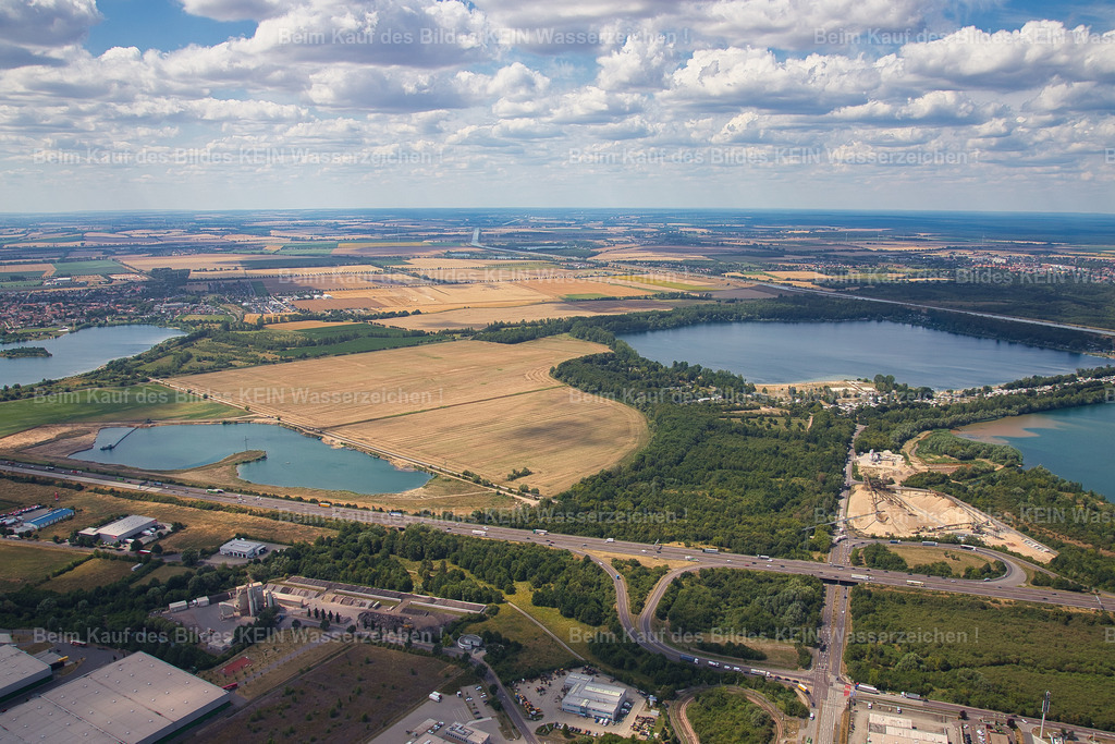Kieswerk_Hülskens_Magdeburg_1163 | Blick aus großer Höhe auf das Kieswerk Rothensee in Magdeburg und das rund drei Kilometer entfernte Abbaugebiet. Das Luftbild macht den räumlichen Zusammenhang zwischen dem Verarbeitungsstandort und dem See sichtbar, in dem der Kies gefördert wird.Aus dieser Perspektive wird deutlich, welche Entfernungen und Flächen bei der Gewinnung und Verarbeitung von Rohstoffen eine Rolle spielen. Das Kieswerk selbst liegt im Vordergrund, während das Abbaugebiet als großer See in der Landschaft erkennbar ist.Die Aufnahme entstand im Rahmen einer umfassenden fotografischen Dokumentation des Kieswerks. Der Kunde wollte nicht nur das Betriebsgelände selbst darstellen, sondern auch die Verbindung zwischen Gewinnungsgebiet und Verarbeitungsstandort sichtbar machen.Damit bildet dieses großräumige Luftbild den Auftakt zu einer Serie, die den Standort aus verschiedenen Perspektiven zeigt – vom Überblick über die Drohnenaufnahme bis hin zu technischen Details, die direkt vor Ort mit der klassischen Kamera fotografiert wurden. - Realisiert mit Pictrs.com