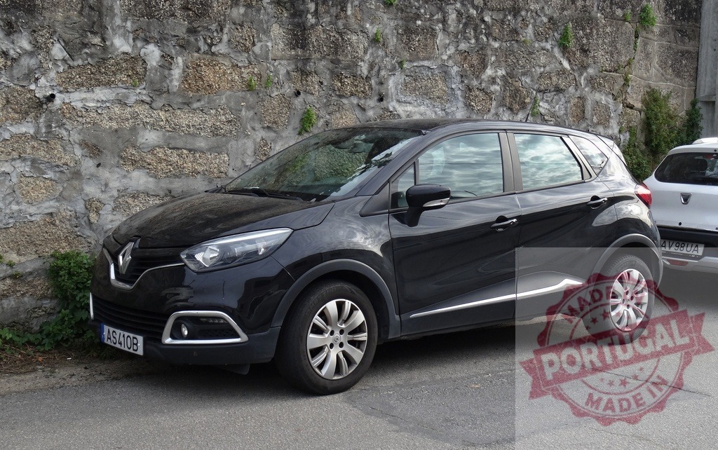 Black Renault Captur SUV parked by stone wall | Black Renault Captur SUV crossover parked on asphalt street next to old stone wall - Realized with Pictrs.com
