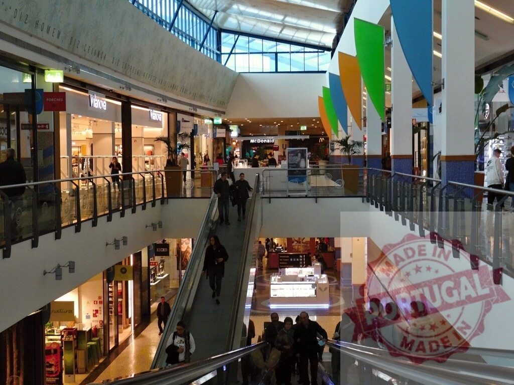 People using escalators in modern shopping mall interior | People are shopping and moving between floors in a busy multi-level retail mall - Realisiert mit Pictrs.com