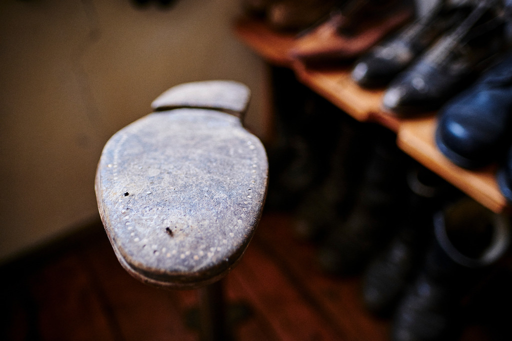Innenraum einer Schuhwerkstatt mit Schuh | Mönchhof, Austria - October 06, 2021: Dorfmuseum Mönchhof; Innenraum einer Schuhwerkstatt mit Holzstifte genagelter Schuhsohle. - Realisiert mit Pictrs.com
