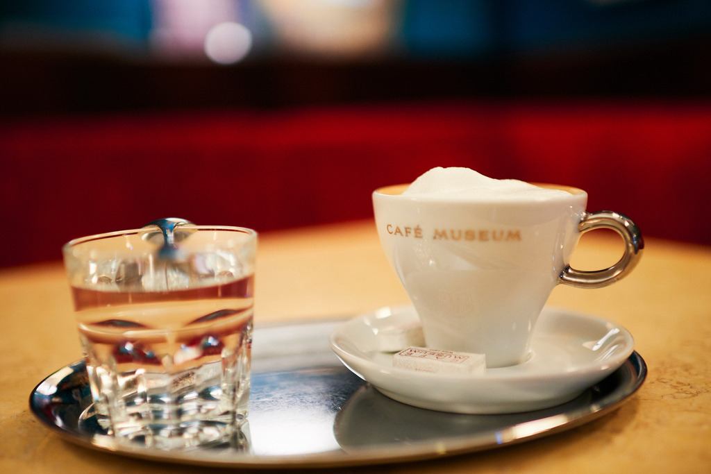 Cafe Museum | Wien, Austria - June 22, 2018: Café Museum, eine Tasse Melange und ein Glas Wasser auf dem Tisch stehend. - Realisiert mit Pictrs.com