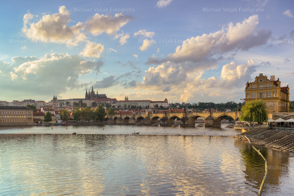 Blick zur Prager Burg | Die Karlsbrücke, majestätisch auf 16 Pfeilern über die Moldau gespannt, ist eine der bekanntesten Sehenswürdigkeiten in Prag. Bei Tag und Nacht fasziniert sie Besucher mit ihrer reichen Geschichte und beeindruckenden Architektur. Doch besonders kurz vor Sonnenuntergang entfaltet sich ihre Magie.Von der Brücke aus bietet sich ein atemberaubender Blick auf die Prager Burg, hier im Hintergrund. Die Burg thront auf einem Hügel und erzählt Geschichten aus mehr als tausend Jahren europäischer Historie. Einst Sitz der Könige von Böhmen, ist sie heute die Residenz des tschechischen Präsidenten. - Realisiert mit Pictrs.com