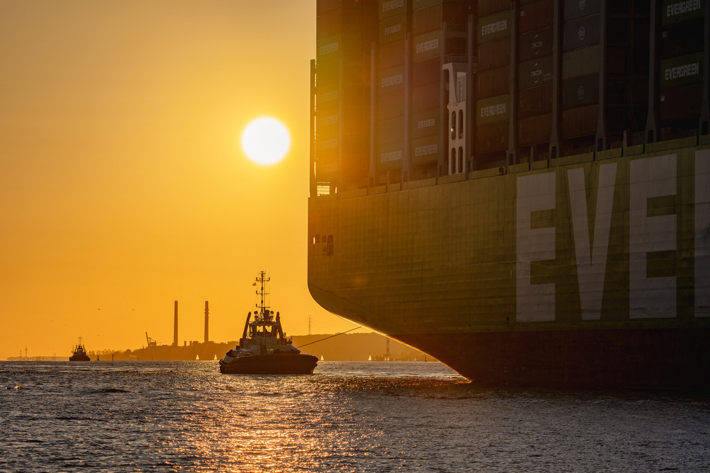 Schlepper am Heck der EVER AEON | Der Schlepper VB Bison am Heck der EVER AEON bei Sonnenuntergang - Realisiert mit Pictrs.com
