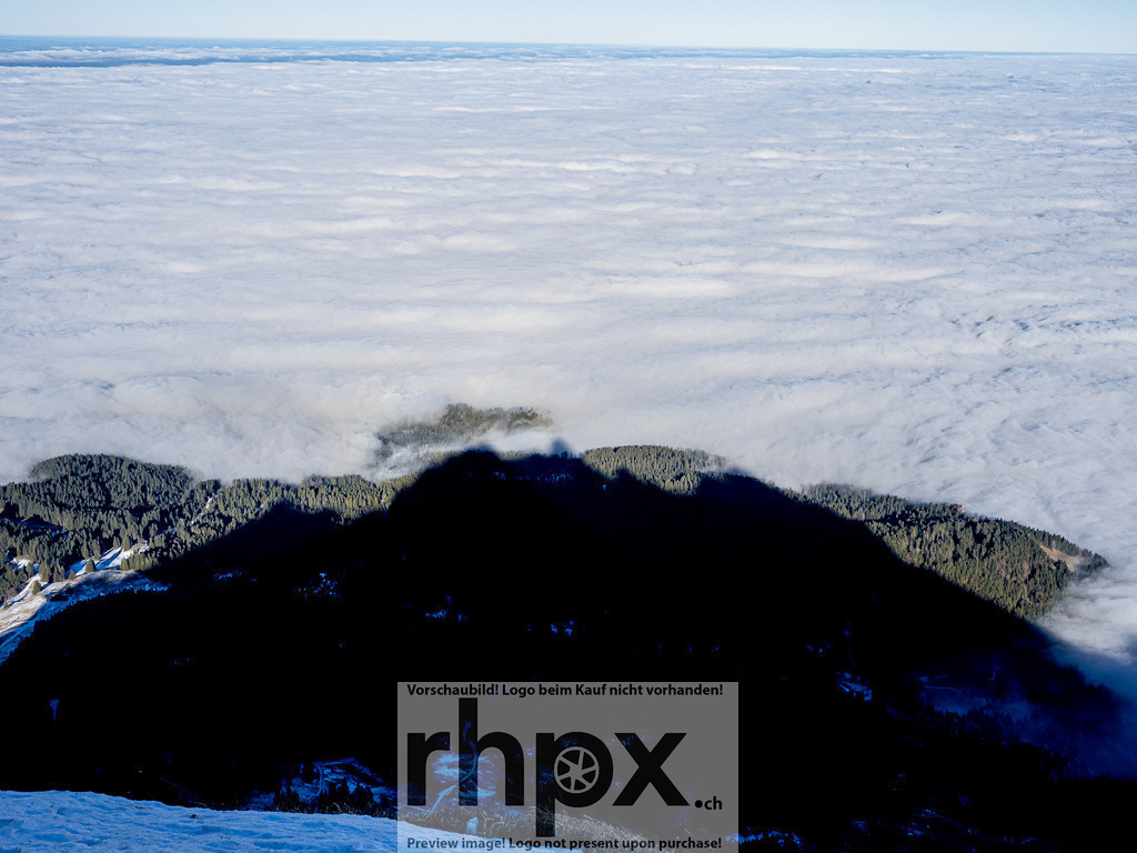 Schatten des Pilatus über dem Nebelmeer | <p><strong>Schatten. Licht. Tiefe.</strong></p>
<p>Die markante Silhouette des Pilatus legt sich als gigantischer Schatten über das dichte Nebelmeer und die dunklen Tannenwälder. Ein faszinierendes Naturschauspiel, das die gewaltigen Dimensionen des Massivs auf eindrucksvolle Weise sichtbar macht.</p>
<p>Wähle unter "Produktauswahl" dein Wunschformat: Vom klassischen Wandbild über Puzzle & Tassen bis zum digitalen Download (z.B. als Handy-Hintergrund).</p>
<br> - Realisiert mit Pictrs.com