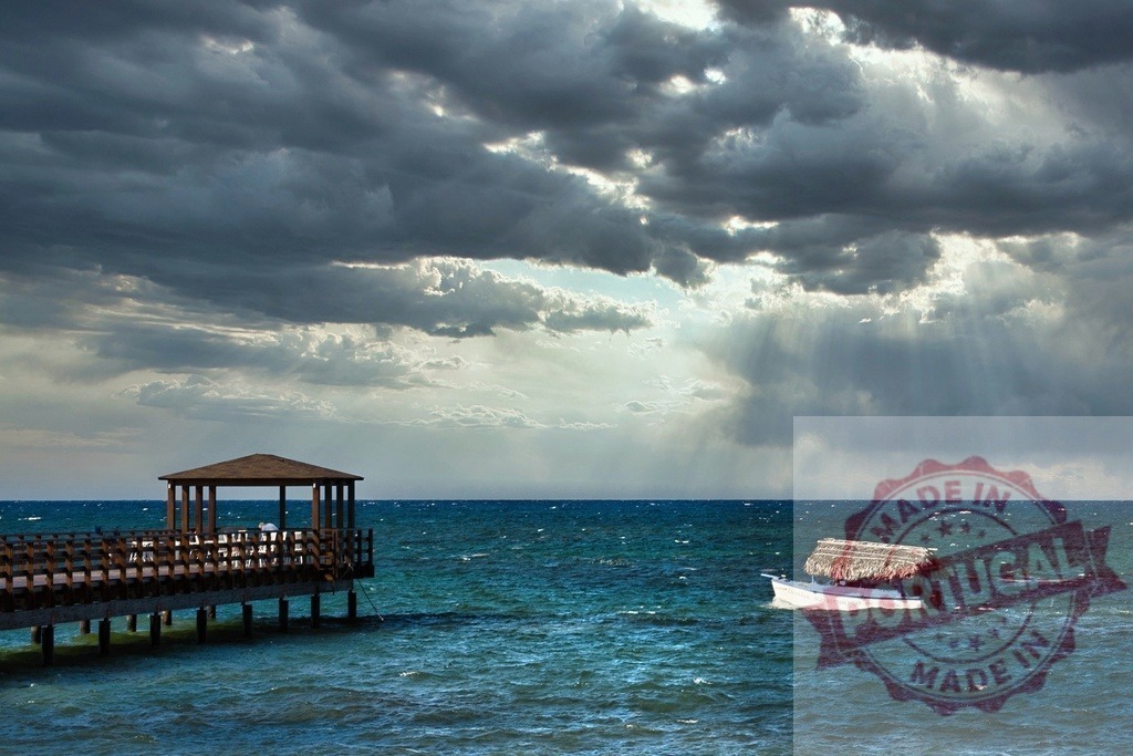 Tropical storm clouds gathering over pier and boat | Dark cumulus clouds, sunlight breaking through, turbulent ocean, Caribbean - Realized with Pictrs.com