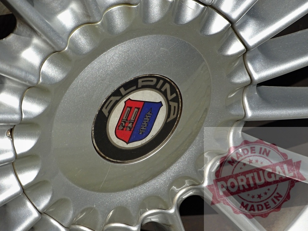 Alpina car wheel hubcap with brand logo | Alpina automotive brand logo displayed on a silver alloy wheel - Realisiert mit Pictrs.com