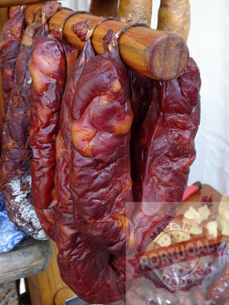Traditional smoked sausage hanging at a street market | Smoked pork sausage hanging on a wooden rack at a food stall - Realisiert mit Pictrs.com