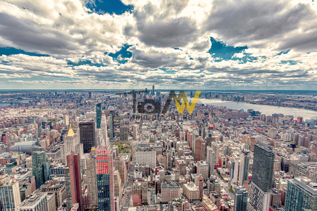 New Yorker Panorama mit sehr vielen Hochhäuser---------USA | Das Bild zeigt eine Luftaufnahme der Skyline von New York City, wahrscheinlich aufgenommen von der Aussichtsplattform des Empire State Building. Die Aufnahme bietet einen weiten Blick über die dicht bebaute Stadtlandschaft Manhattans und darüber hinaus.Im Vordergrund sind mehrere markante Hochhäuser zu sehen, darunter das Chrysler Building und das One World Trade Center in der Ferne. - Realisiert mit Pictrs.com