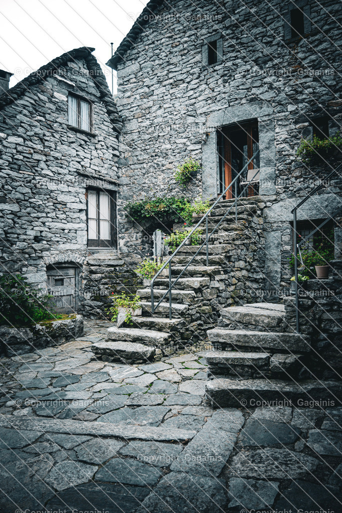 Foroglio nach oben | Foroglio ist ein malerisches Bergdorf im Bavonatal im Tessin, Schweiz. Es ist bekannt für seinen beeindruckenden Wasserfall, der rund 80 Meter tief in das Tal stürzt, sowie für seine traditionellen Steinhäuser, engen Gassen und unberührte alpine Landschaft. Das Dorf wirkt wie aus einer anderen Zeit und zieht Natur- und Fotoliebhaber gleichermaßen an.