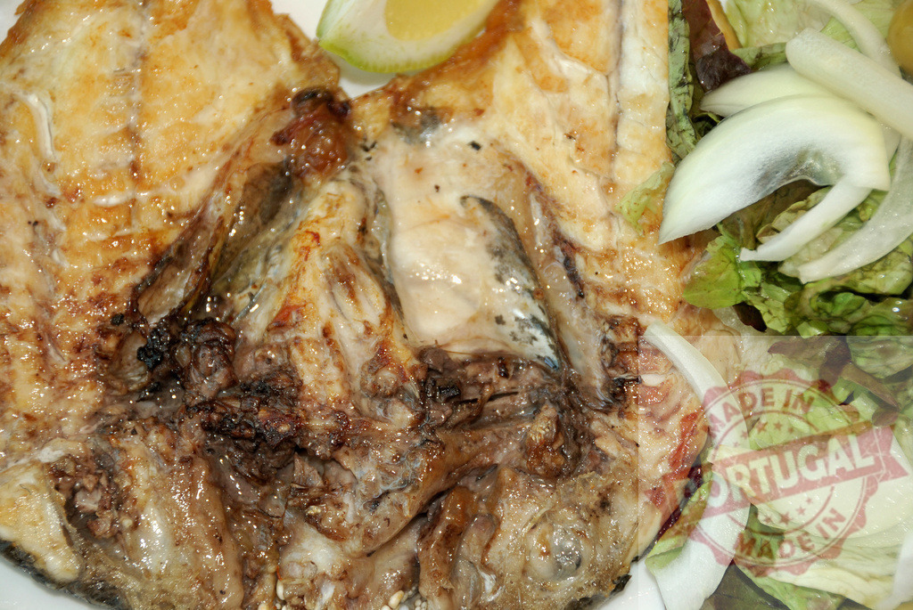 Grilled fish serving with fresh lemon and salad | Grilled fish with golden skin and a side of fresh salad, perfect for a healthy meal - Realized with Pictrs.com