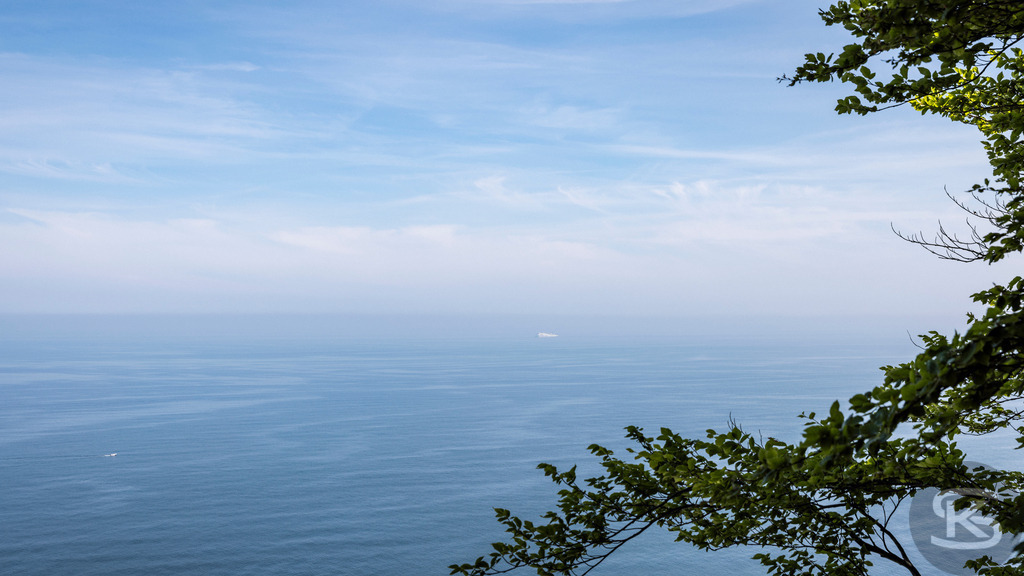 Ausblick über die Ostsee vom Nationalpark Jasmund  | Ausblick von den weißen Kreidefelsen im Nationalpark Jasmund der Insel Rügen über die Ostsee und umgeben von grünem Buchenwald. - Realisiert mit Pictrs.com