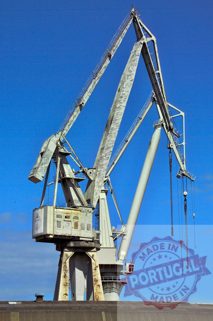 Industrial harbor crane under blue sky lifting cargo. Spain - Bilbao | Heavy duty port crane standing against clear blue sky in industrial setting - Realisiert mit Pictrs.com