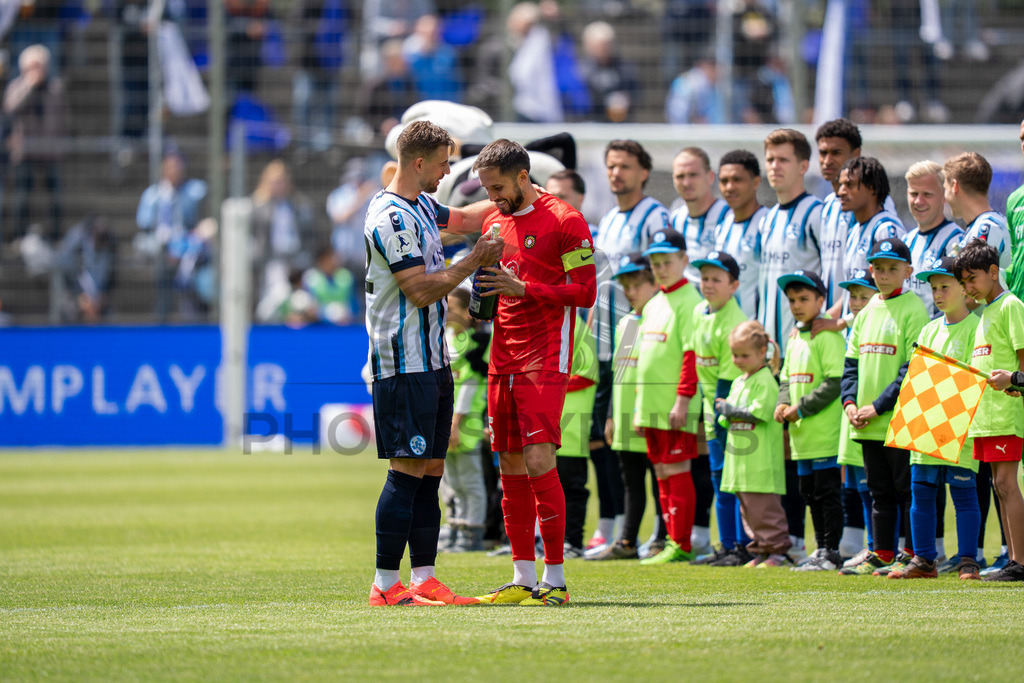 Stuttgarter Kickers vs. SG Sonnenhof Großaspach, Fussball, Regionalliga Suedwest, 34. Spieltag, 16.05.2026 | David Braig (Stuttgarter Kickers, #22) uebergibt ein Geschenk an Volkan Celiktas (SG Sonnenhof Großaspach, #05) zur Meisterschaft und dem Aufstieg,Stuttgarter Kickers vs. SG Sonnenhof Großaspach, Fussball, Regionalliga Suedwest, 34. Spieltag, 16.05.2026