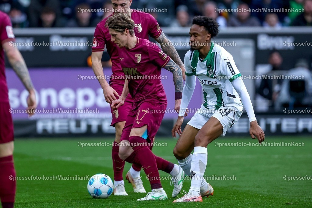 BMG21022501033 | 22.02.2025, Fußball, Borussia Mönchengladbach - FC Augsburg, 1. Fußball Bundesliga, Borussia-Park, Saison 2024 2025: Kristijan Jakic (FC Augsburg #17) im Zweikampf gegen Nathan Ngoumou (Mönchengl. #19)DFB regulations prohibit any use of photographs as image sequences and or quasi-video.