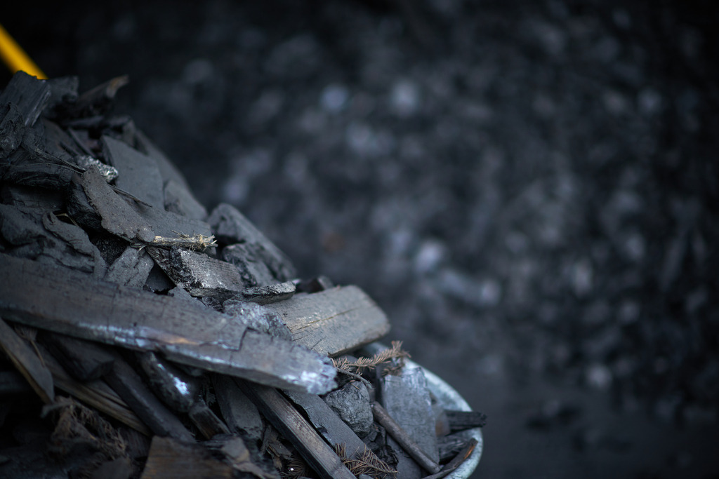 Detail auf dem Kohlplatz | Michelbach, Austria - May 08, 2019: Waldköhlerei Hochecker, die 2011 in das Nationale Verzeichnis des immateriellen Kulturerbes der UNESCO aufgenommen wurde, produziert noch echte Holzkohle; Detail auf dem Kohlplatz. - Realisiert mit Pictrs.com