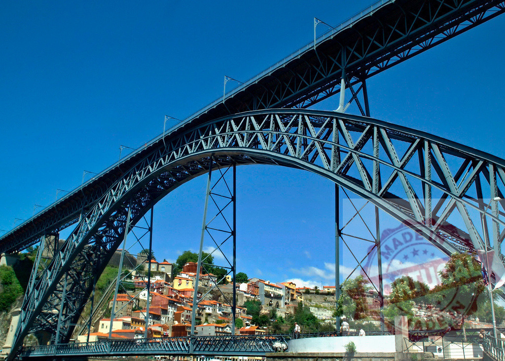 Dom Luís I Bridge arching over Porto city on Douro River | Dom Luís I Bridge spans across the Douro River, showcasing Porto's historic architecture - Realized with Pictrs.com