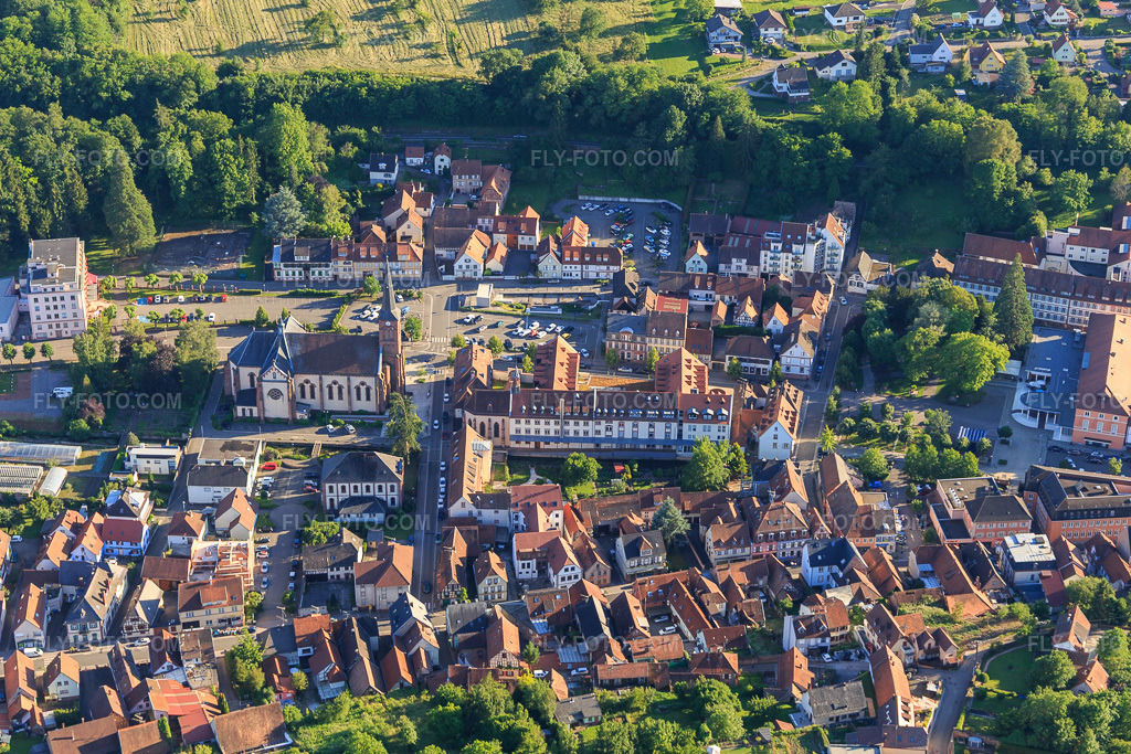 Aerial view: Église Saint-Martin and Pl. Saint-Martin in Niederbronn-les-Bains in the state Bas-Rhin, France. – Photo: IMG_115405.jpg taken on 06/16/2019 by Werner Riehm/FLY-FOTO.com – Resolution of the original: 4905 x 3270 px