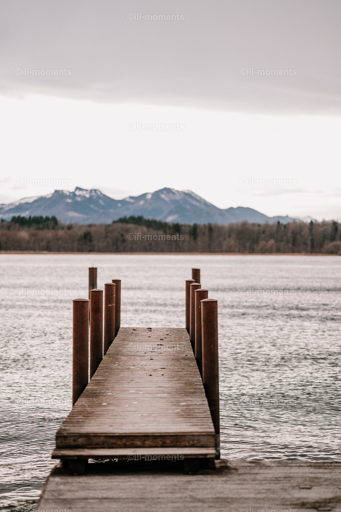 Steg zum See | Ein ruhiger Steg, der in einen klaren See führt, umgeben von Natur – ein stimmungsvolles Fotokunstwerk voller Ruhe und Weite. Perfekt als Kunstdruck für Räume mit entspannter Atmosphäre und natürlicher Schönheit. - Realisiert mit Pictrs.com