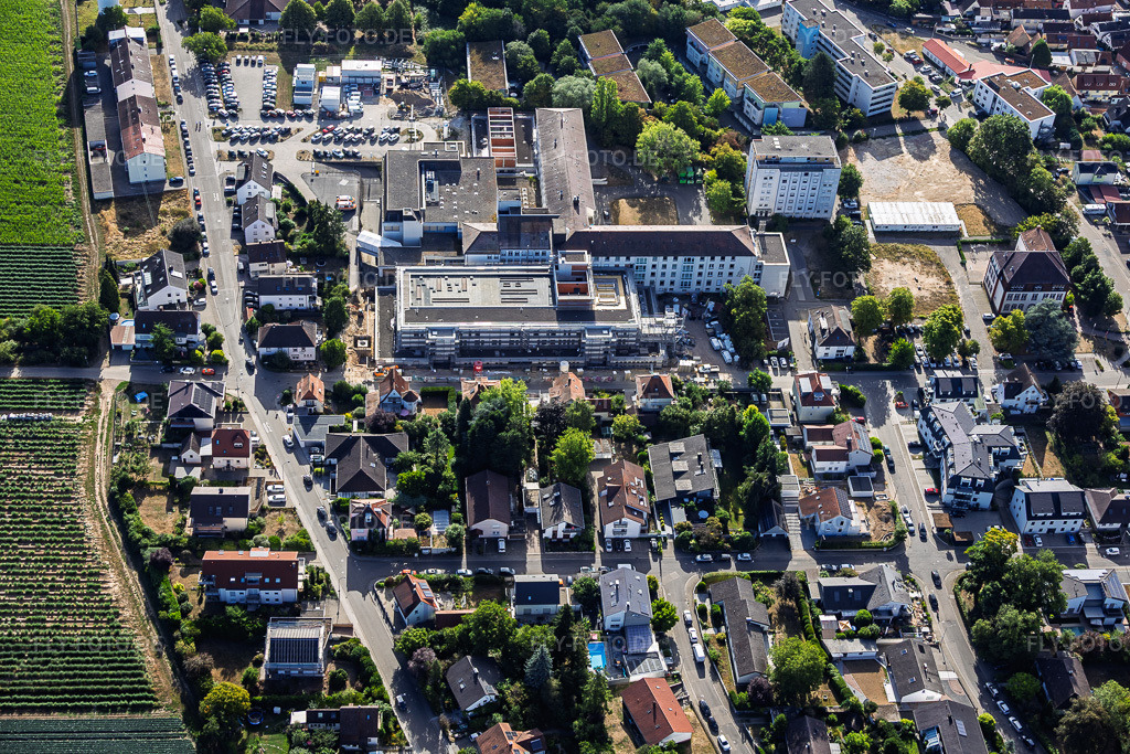 Luftbild: Baustelle für den NEUBAU der NOTAUFNAHME, INTENSIVMEDIZIN UND DIAGNOSTIKBEREICHE der Asklepios Südpfalzkliniken GmbH. Projektsteuerung: BPM Bau- und Projektmanagement Hart GmbH. BPM Architektur, Planung + Objektüberwachung: alsh sander hofrichter architekten GmbH Gesellschaft für Architektur und Generalplanung. Planungsbüro Noll GmbH , TGA-Planung / Heizung-Lüftung-Sanitär-Medizinische Gase-Gebäudeautomation, TGA-Planung / Stark- u. Schwachstromtechnische Anlagen / Fördertechnik: DE-Plan GmbH & Co. KG, Tragwerksplanung: ZPP Ingenieure AG, Freianlagen hofmann_röttgen Landschaftsarchitekten BDLA, Brandschutz: Rieser-Wessel Brandschutzsachverständige & Ingenieure PartG mbB und Bauphysik / Schallschutz-Akustik: Ingenieurbüro Seidel in Kandel im Bundesland Rheinland-Pfalz in Deutschland. – Foto: IMG_158362.jpg vom 06.08.2026 durch Werner Riehm/FLY-FOTO.de – Auflösung des Originals: 6000 x 4000 px – Asklepios Südpfalzklinik Kandel - Asklepios Südpfalzklinik Kandel – BPM – a|sh – WWW.PLANUNGSBUERO-NOLL.DE – DE Plan - DE-Plan GmbH & Co. KG., Gladenbach, Planungsbüro – WWW.SOCOTEC.DE – Start | Hofmann-Röttgen Landschaftsarchitekten – RIESER-BRANDSCHUTZ.DE – Ingenieurbüro Seidel Bauphysik und Brandschutz | Ingenieurbüro Seidel