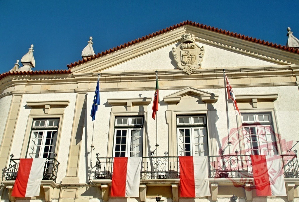 Alcobaça City Hall building with Portugal and EU flags | Alcobaça City Hall featuring traditional architecture, a coat of arms, and national flags - Realisiert mit Pictrs.com