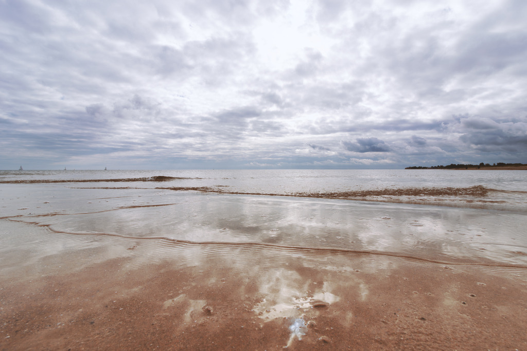 Wandbild: Wolken spiegeln sich im flachen Wasser der Ostsee | Dieses Wandbild im Querformat zeigt die beeindruckende Spiegelung der Wolken auf dem ruhigen Wasser der Ostsee. Der bewölkte, aber sonnige Tag verleiht der Szene eine harmonische und beruhigende Stimmung. Holen Sie sich dieses maritime Kunstwerk in Ihr Zuhause und genießen Sie die ruhige Schönheit des Meeres. - Realisiert mit Pictrs.com