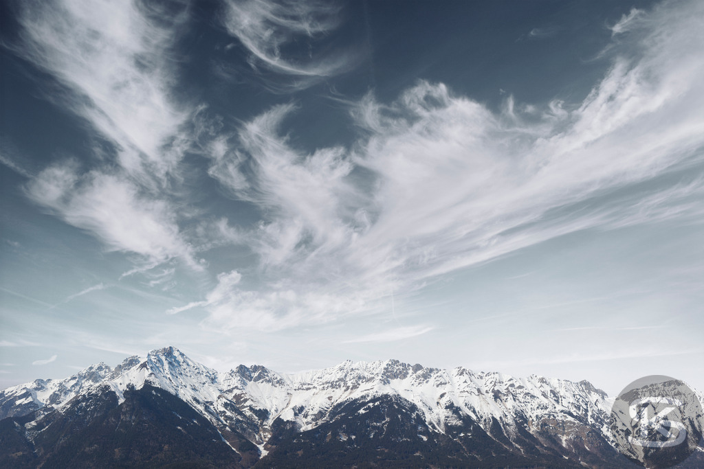 Verschneite Alpengipfel unter dramatischem Wolkenhimmel - Bergpanorama Nordkette Innsbruck | Beeindruckendes Bergpanorama mit schneebedeckten Alpengipfeln unter einem spektakulären Wolkenhimmel. Majestätische Gebirgskette mit dramatischen Cirruswolken und winterlicher Stimmung in den Alpen. - Realisiert mit Pictrs.com