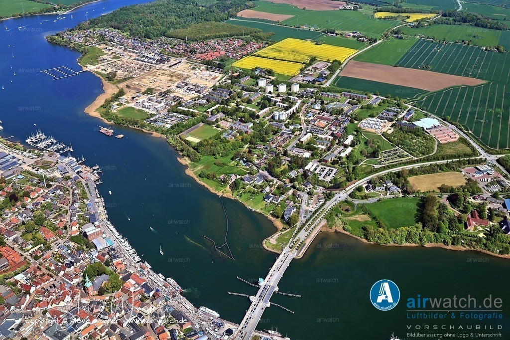 Luftbild Kappeln an der Schlei & Ellenberg | Kappeln beherbergt den einzigen noch funktionstüchtigen Heringszaun Europas, der bis ins 15. Jahrhundert zurückreicht. Diese traditionelle Fischfangmethode nutzt ein System aus über 2.000 in den Meeresboden gerammten Pfählen, die Heringe auf ihrem Laichweg in die Schlei leiten. Der Zaun ist denkmalgeschützt und kann besonders gut von der Schleibrücke oder dem Hafen aus beobachtet werden.