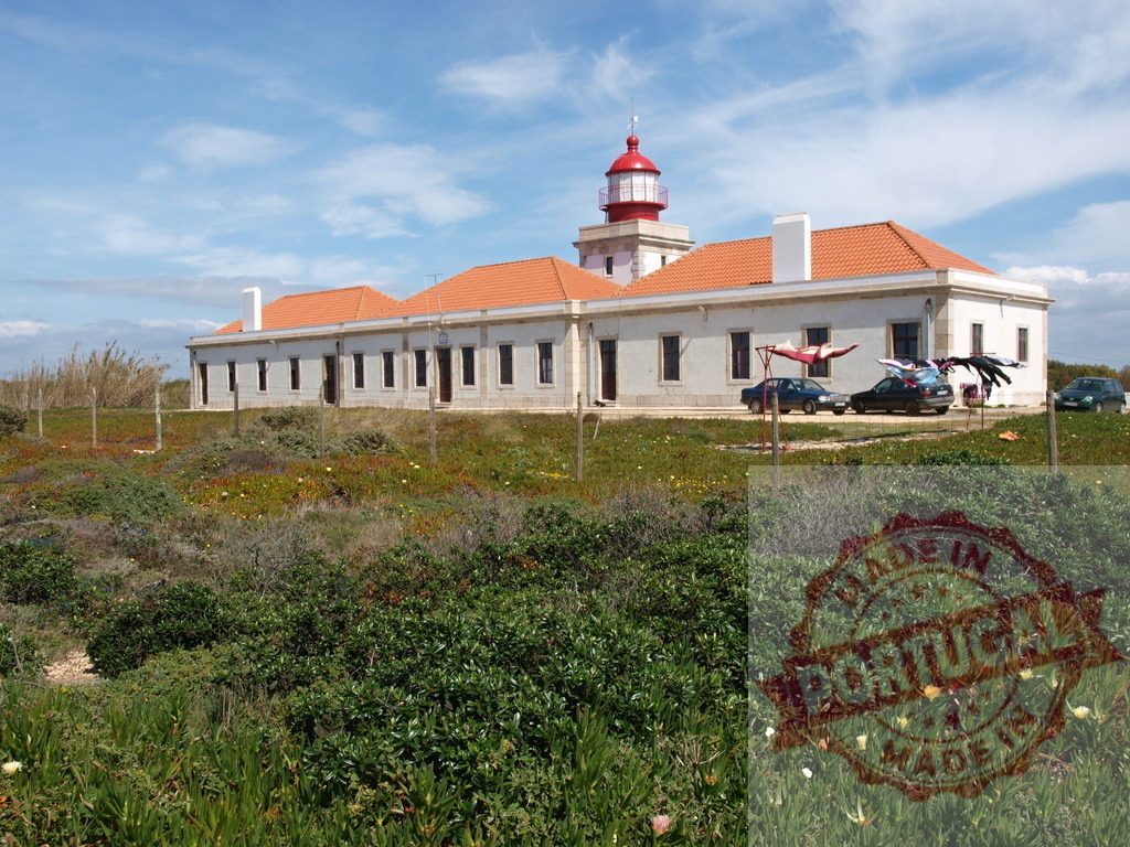 Farol do Penedo da Saudade lighthouse standing on a sunny day | Farol do Penedo da Saudade lighthouse and support buildings on a coastal landscape with green vegetation - Realisiert mit Pictrs.com