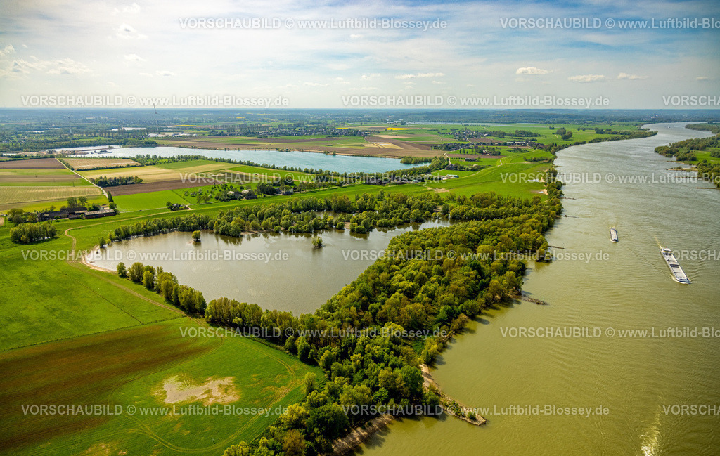 Wesel240402124RheinvorlandPerrich | Luftbild, Rheinvorland Perrich mit See und bewaldetem Uferbereich, dahinter Hülskens Kieswerk Baggersee, Binnenschifffahrt auf dem Fluss Rhein, Fernsicht, Perrich, Wesel, Niederrhein, Nordrhein-Westfalen, Deutschland