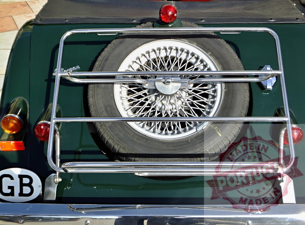 Spare tire with spokes is fixed on luggage rack of vintage english car | Close-up of a spare tire mounted on the luggage rack of a classic British car, showcasing its vintage charm and meticulous maintenance - Realisiert mit Pictrs.com