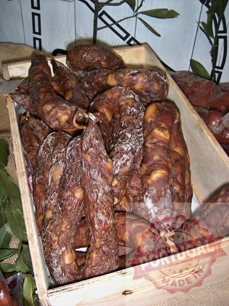 Cured sausages filling wooden crate at food market | Cured traditional sausages displaying rustic texture and rich color in a wooden crate - Realisiert mit Pictrs.com