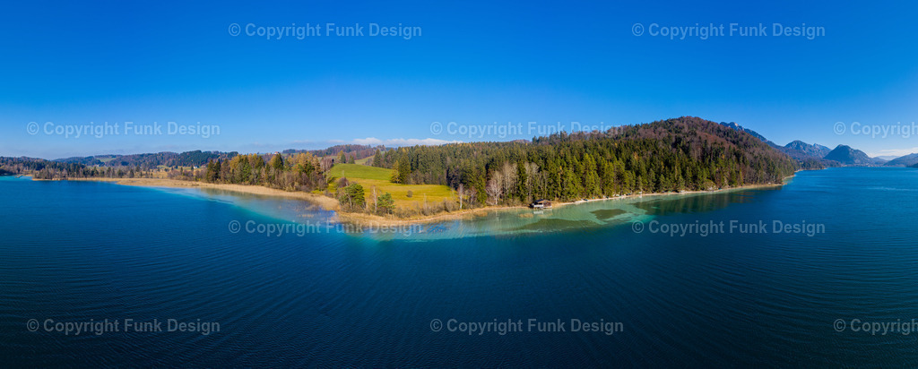Drohnenpanorama am Fuschlsee – Salzburg, Österreich | Ein ruhiges Drohnenpanorama zeigt den Fuschlsee mit seinem tiefblauen Wasser und dem hellen, türkisfarbenen Uferbereich rund um eine bewaldete Halbinsel. Die klare Luft und die sanfte Landschaft machen das Motiv zu einem modernen, beruhigenden Panorama-Wandbild.