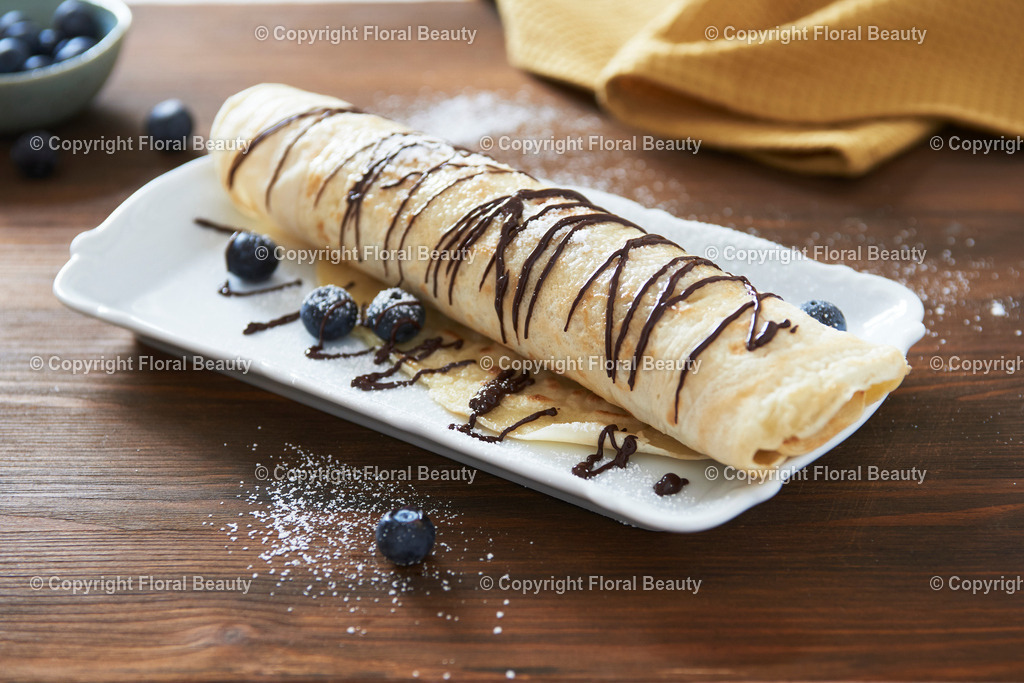 Pfannkuchen mit Blaubeeren und Schokoladenglasur | gerollter Pfannkuchen mit Blaubeeren und Schokoverzierung - Realisiert mit Pictrs.com
